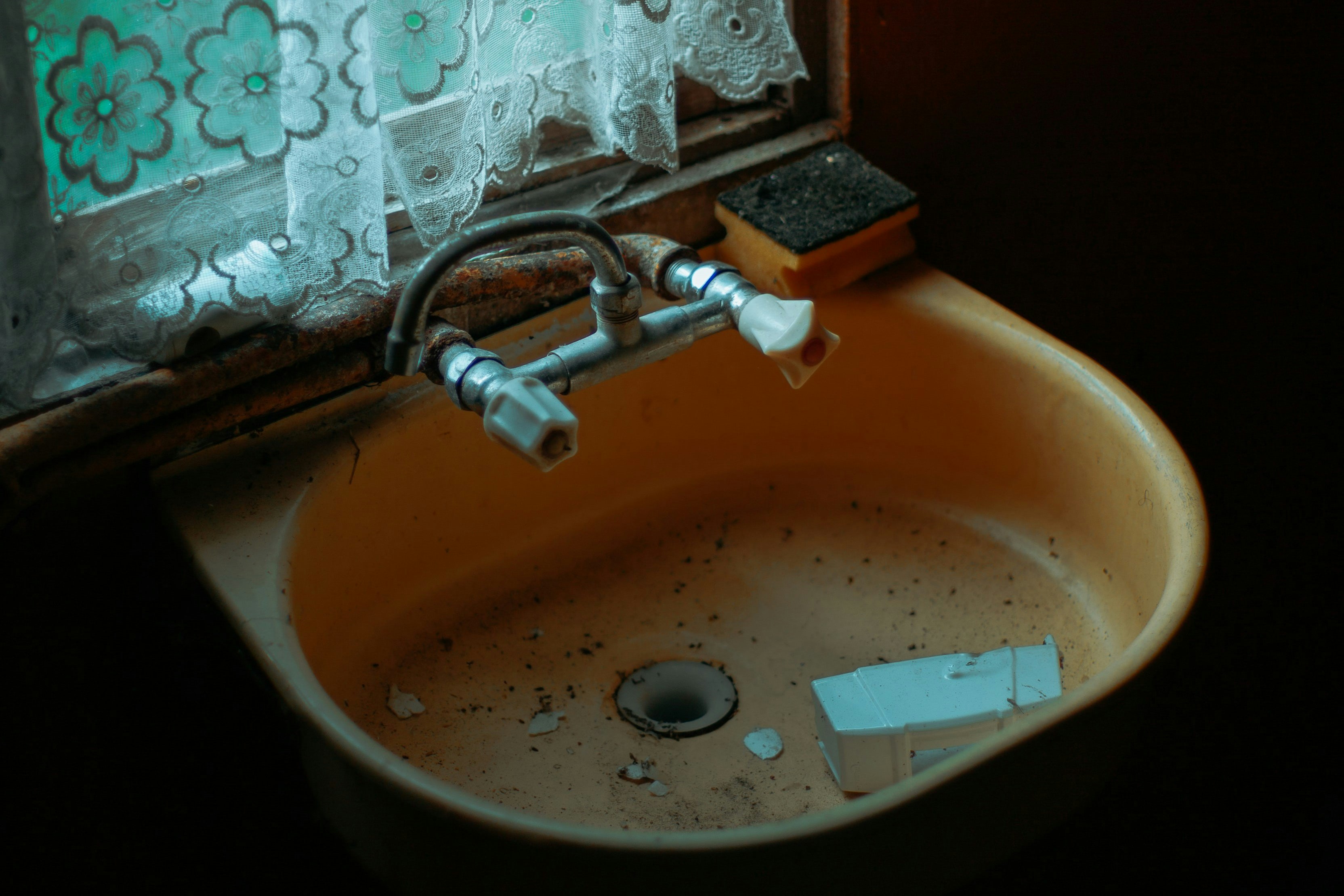 An old, dirty ceramic sink