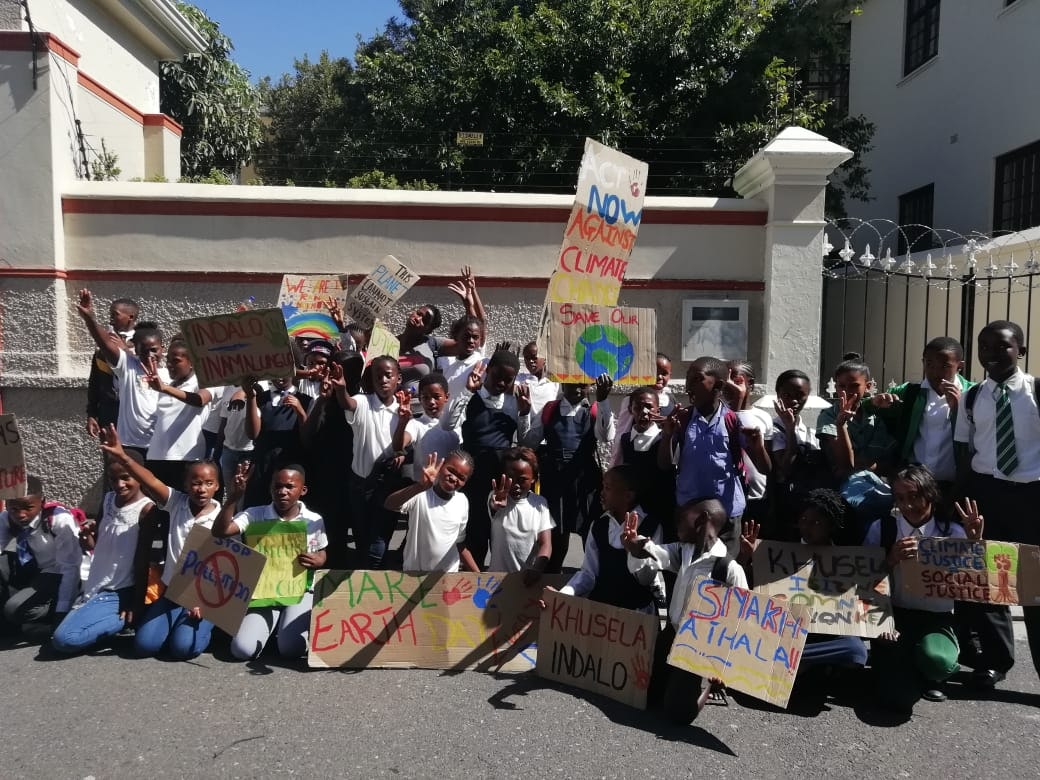 A group of young climate strikers gather with signs in Cape Town, South Africa.