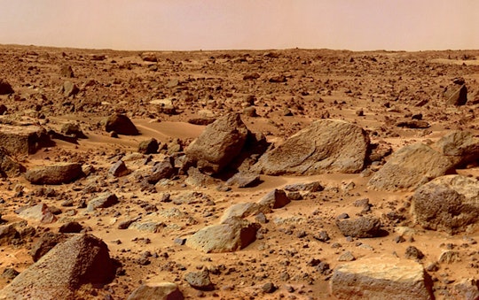 a rocky surface of mars with a pink hazy sky 