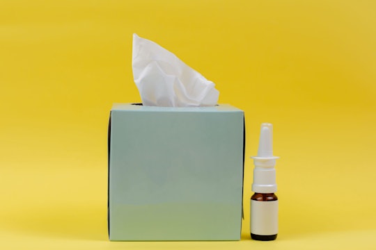 tissue box and allergy meds against a yellow background