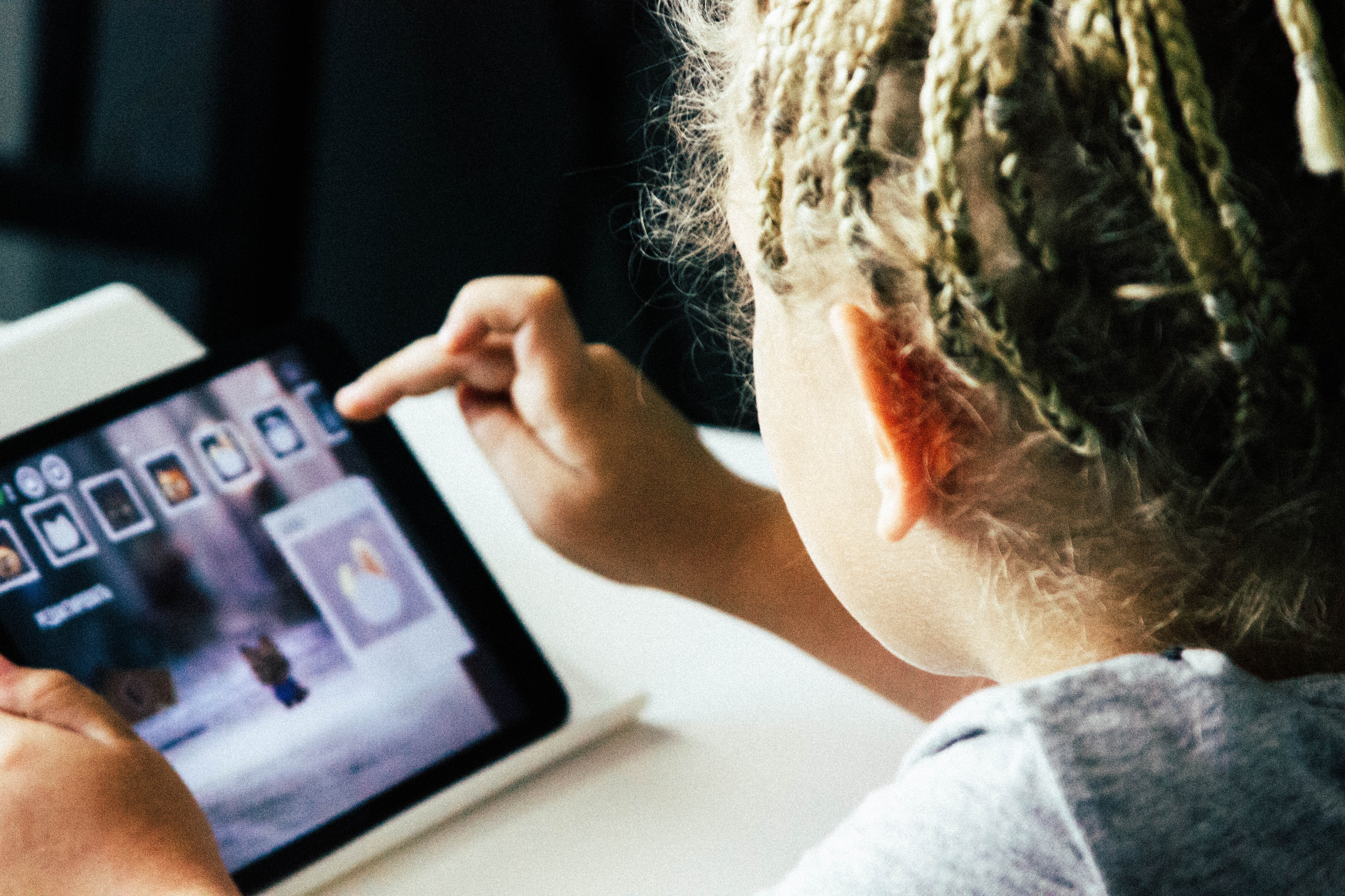 young girl playing on tablet computer