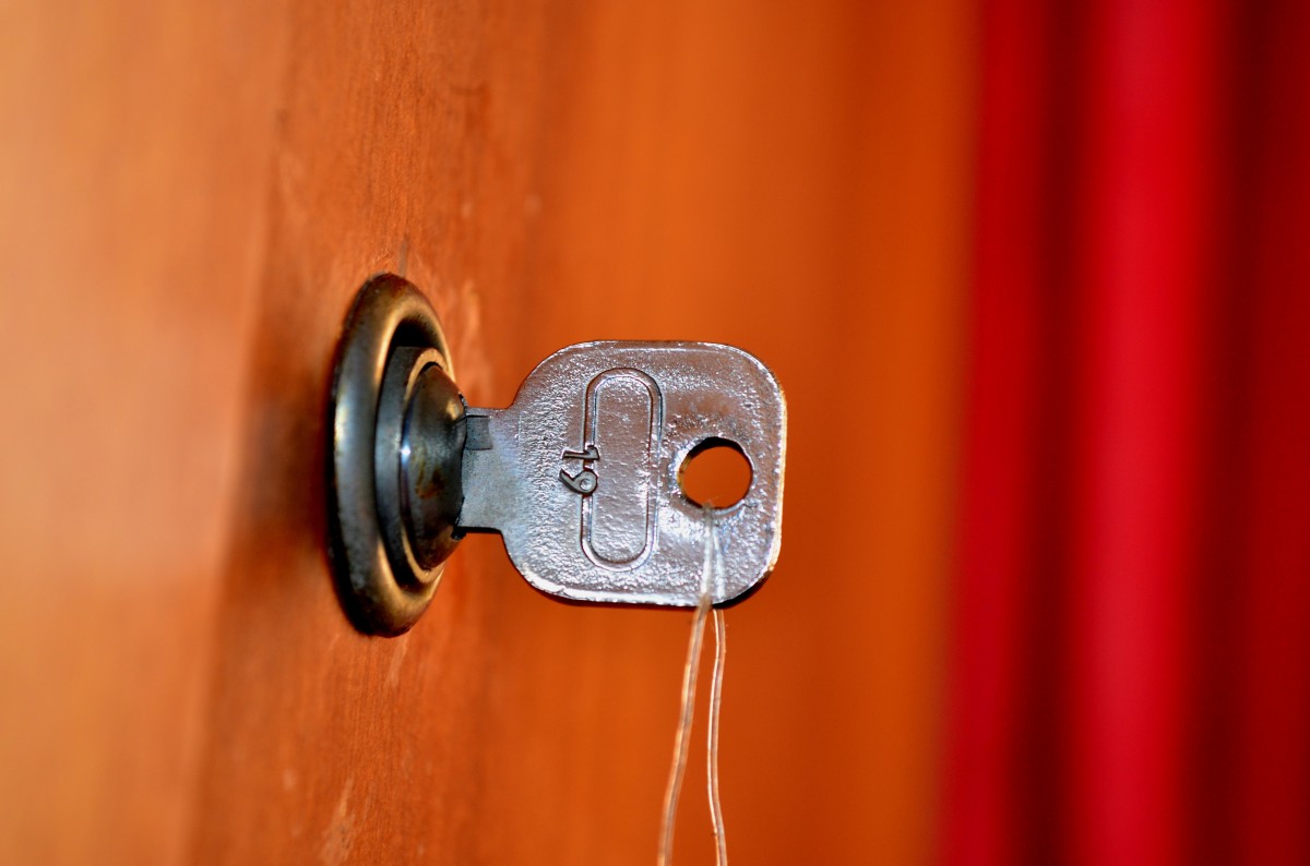 a key in a lock against an orange-brown background