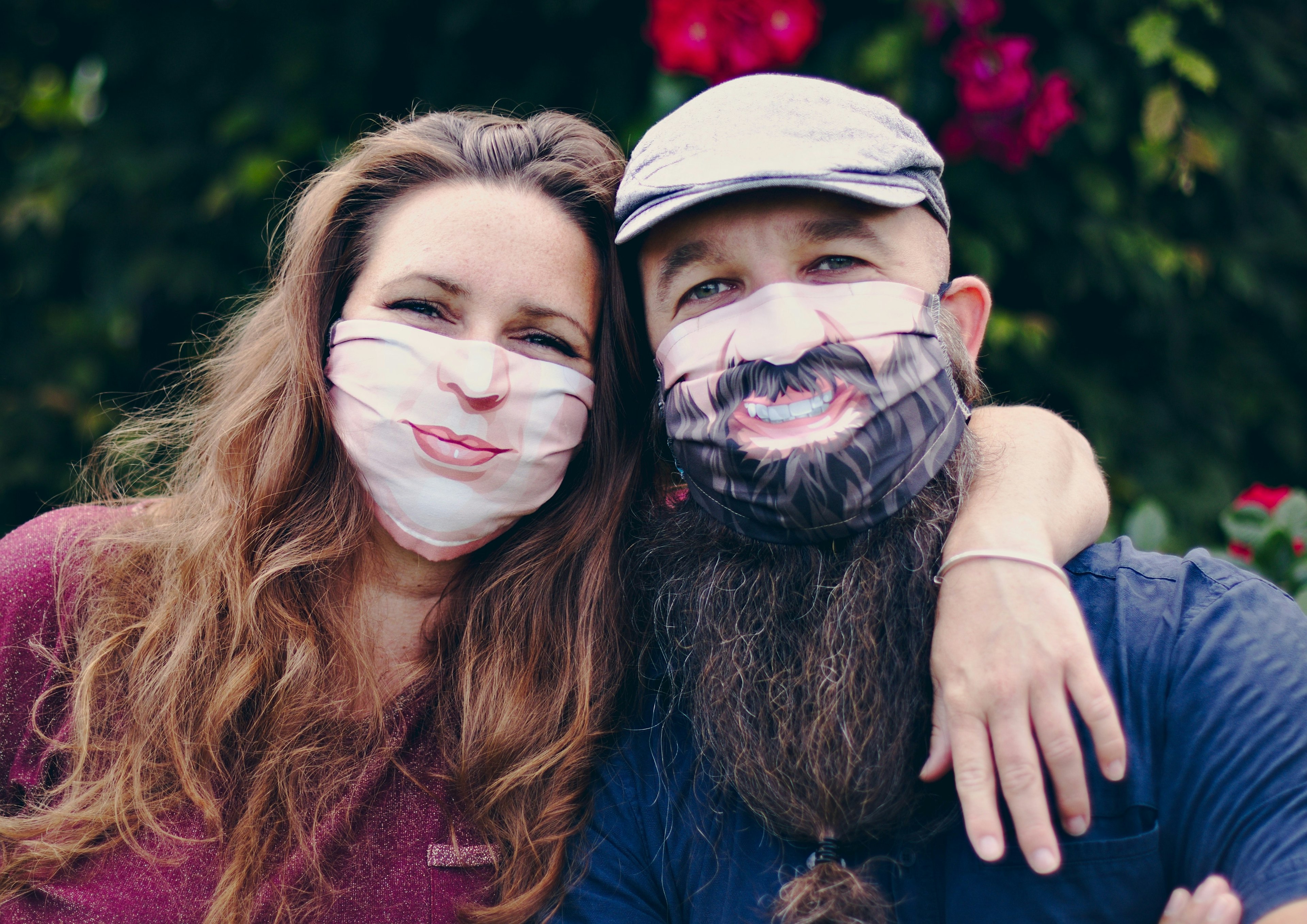 A man and woman wearing face masks with smiles printed on them