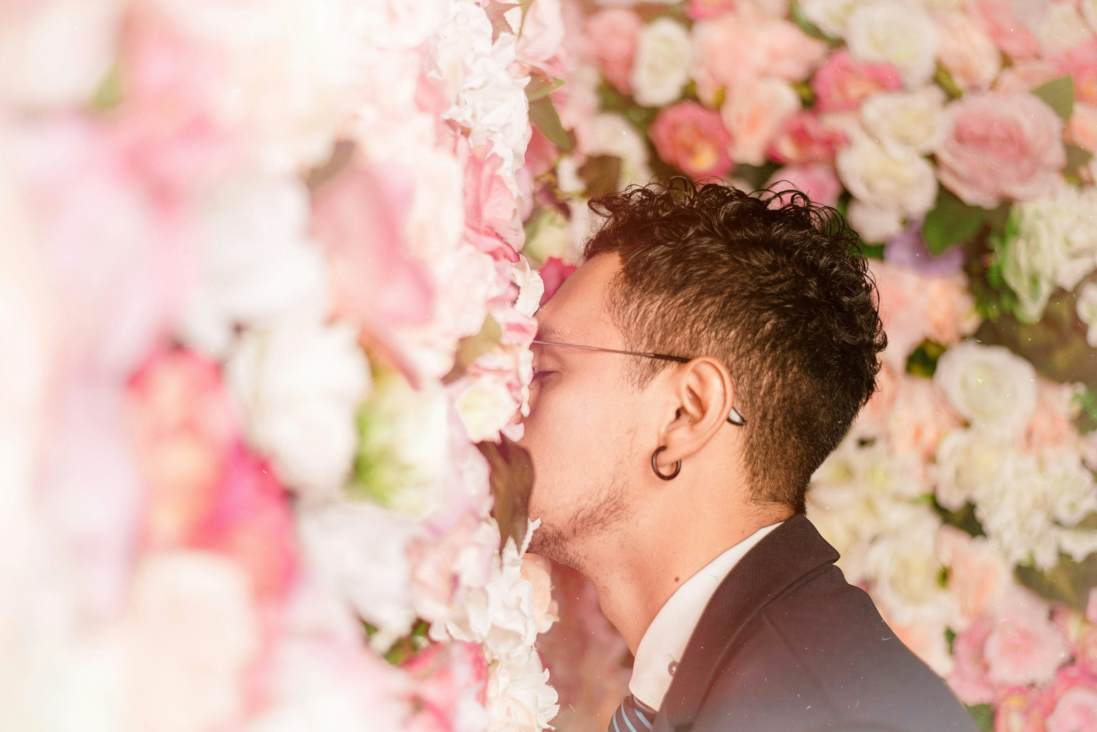 a person with his face pressed into a wall of flowers
