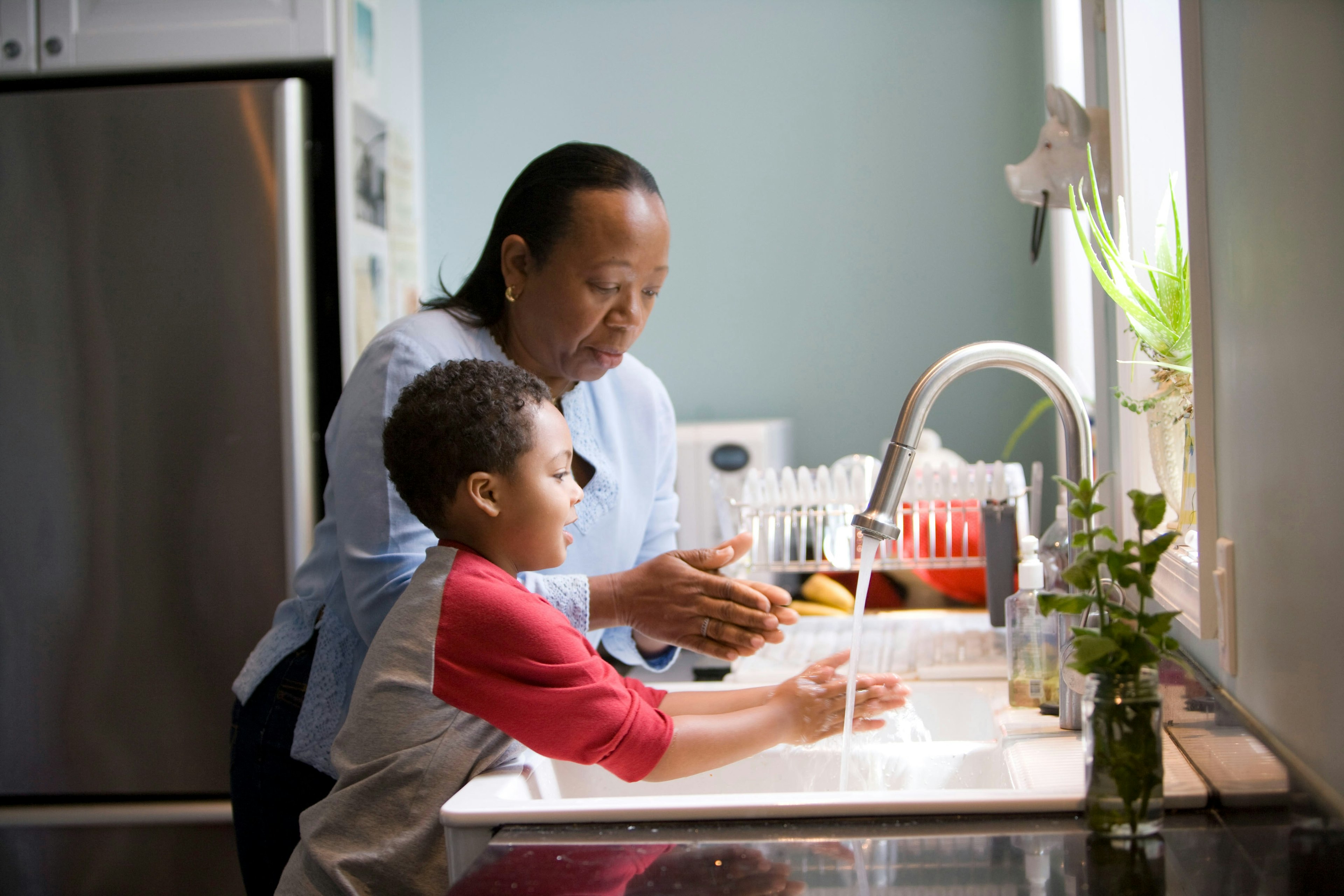 A woman and child washing their hands at the sink