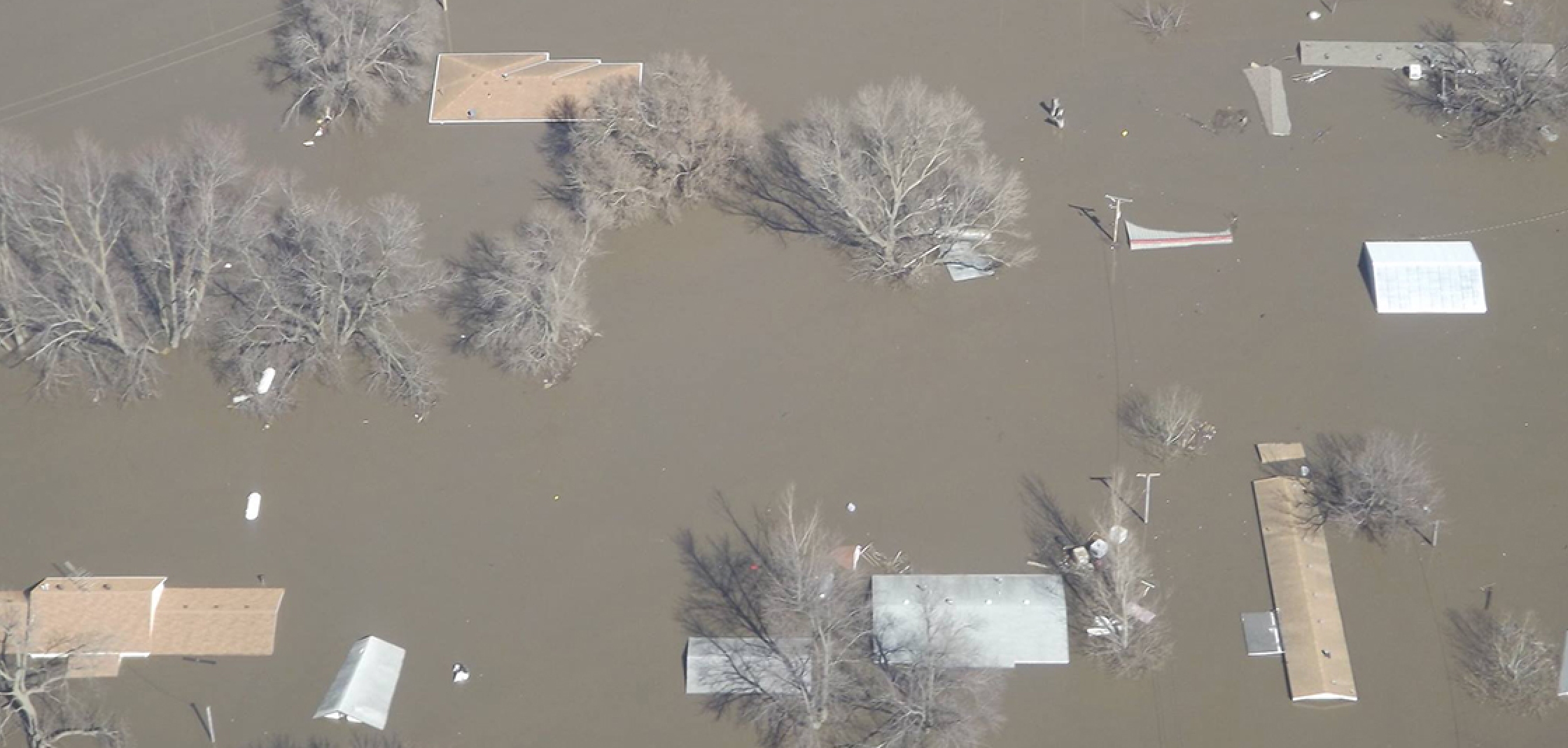 Picture of flooding so severe only the roofs of houses are visible.