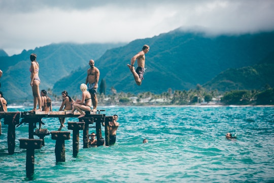 people jumping and swimming in a lake