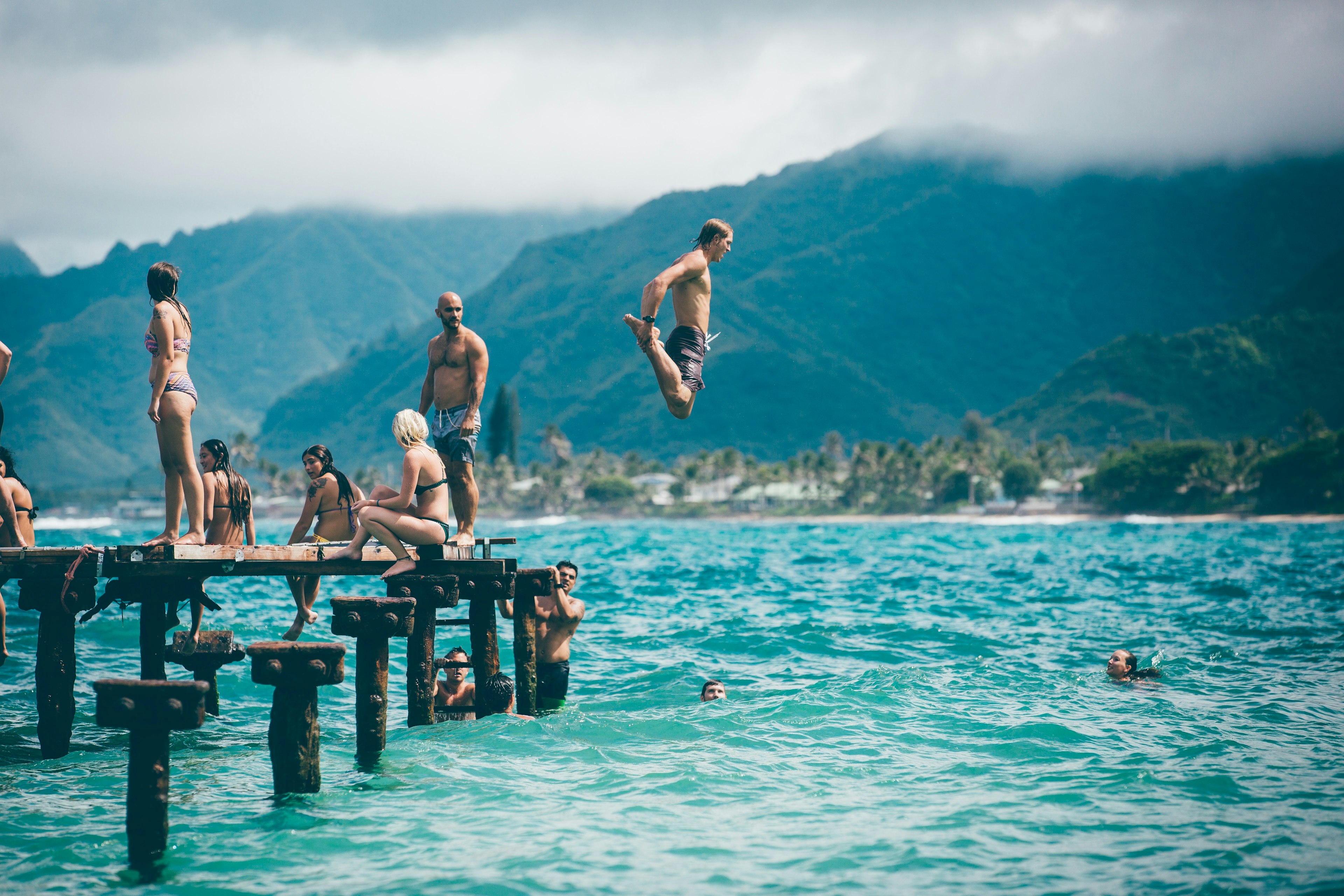 people jumping and swimming in a lake