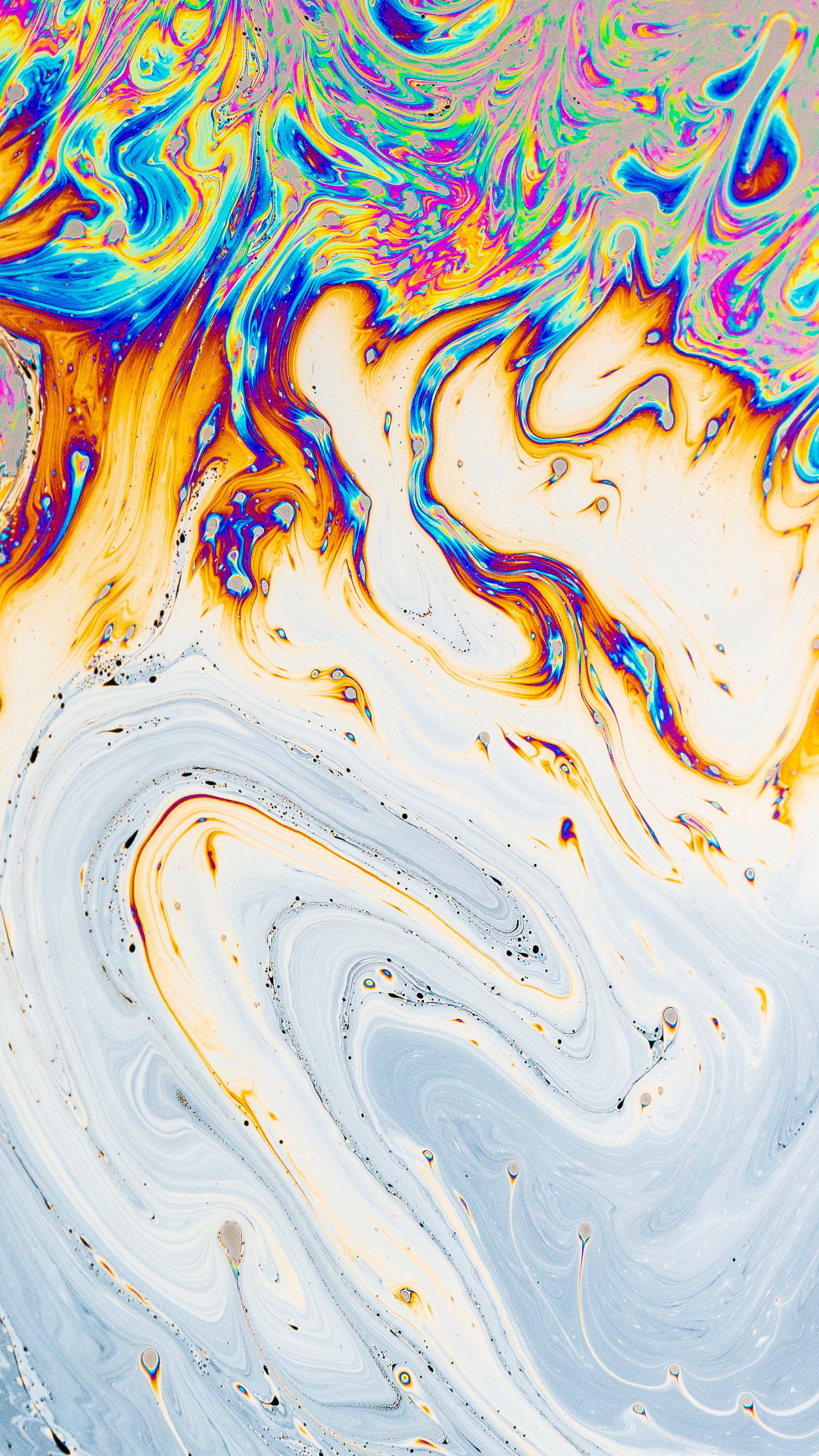 Soap and water mixing to form a multi-colored surface.