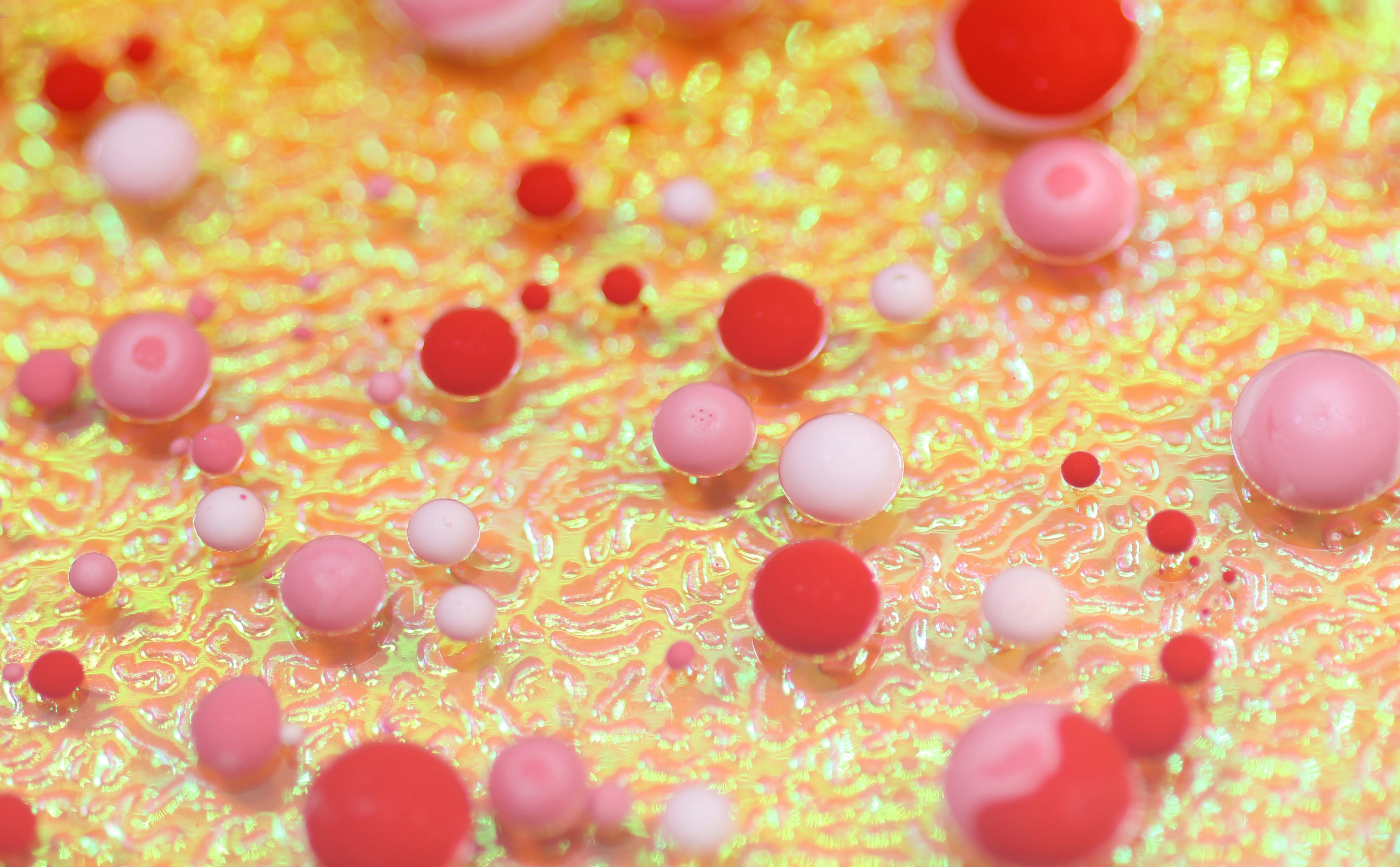 a collection of red, pink, and white blobs against a yellow background