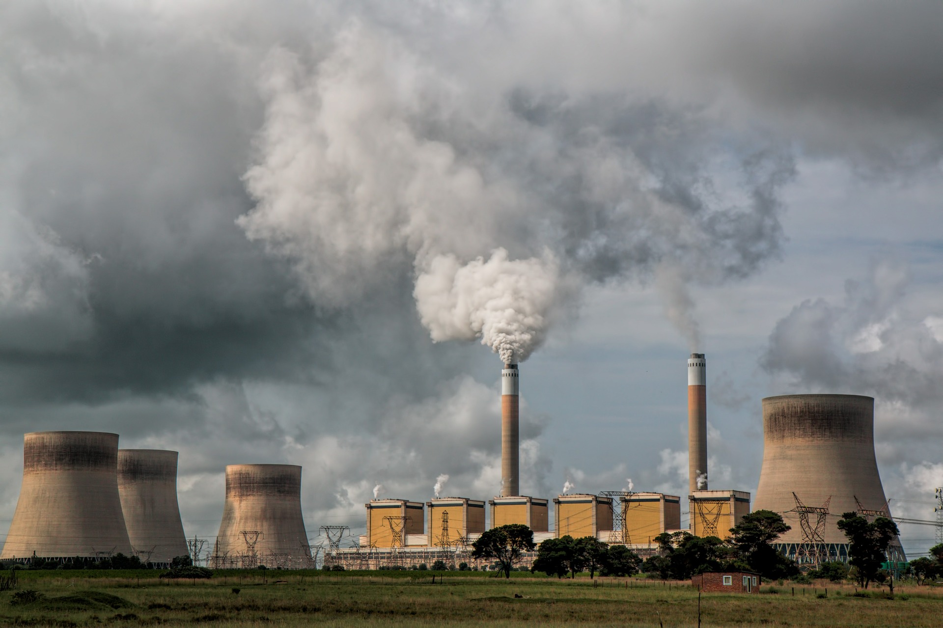 A power plant with gas erupting from a tower.