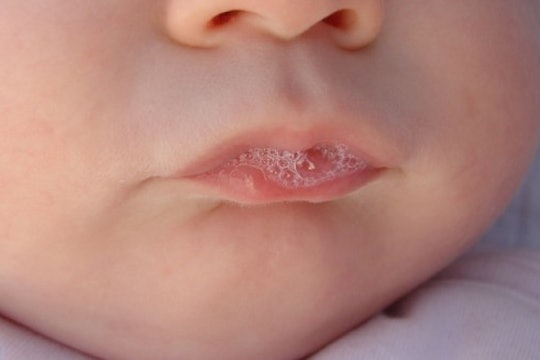ittle baby with saliva on his lips
