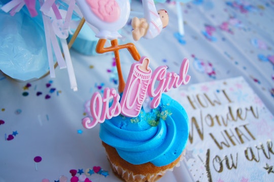 Gender reveal cupcake with blue icing and a pink "it's a girl" decoration Gender reveal cupcake with blue icing and a pink "it's a girl" decoration