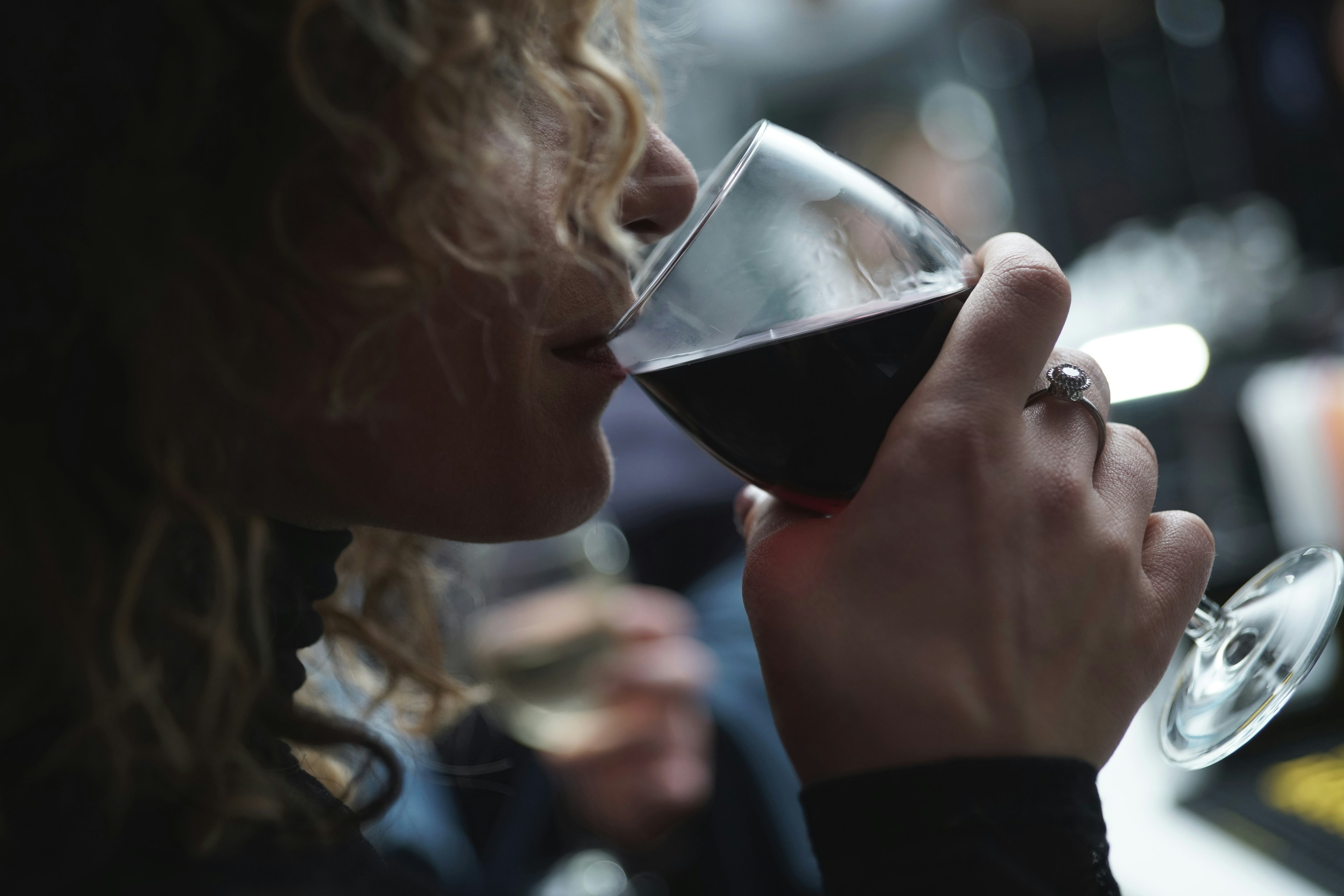 side view of woman drinking a glass of wine