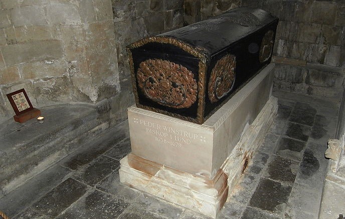 a coffin on a pedestal in a stone room