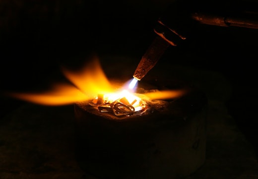 a welder using a torch to melt metal
