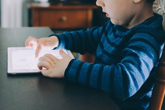 a young boy playing on a tablet computer