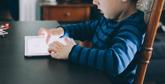 a young boy playing on a tablet computer