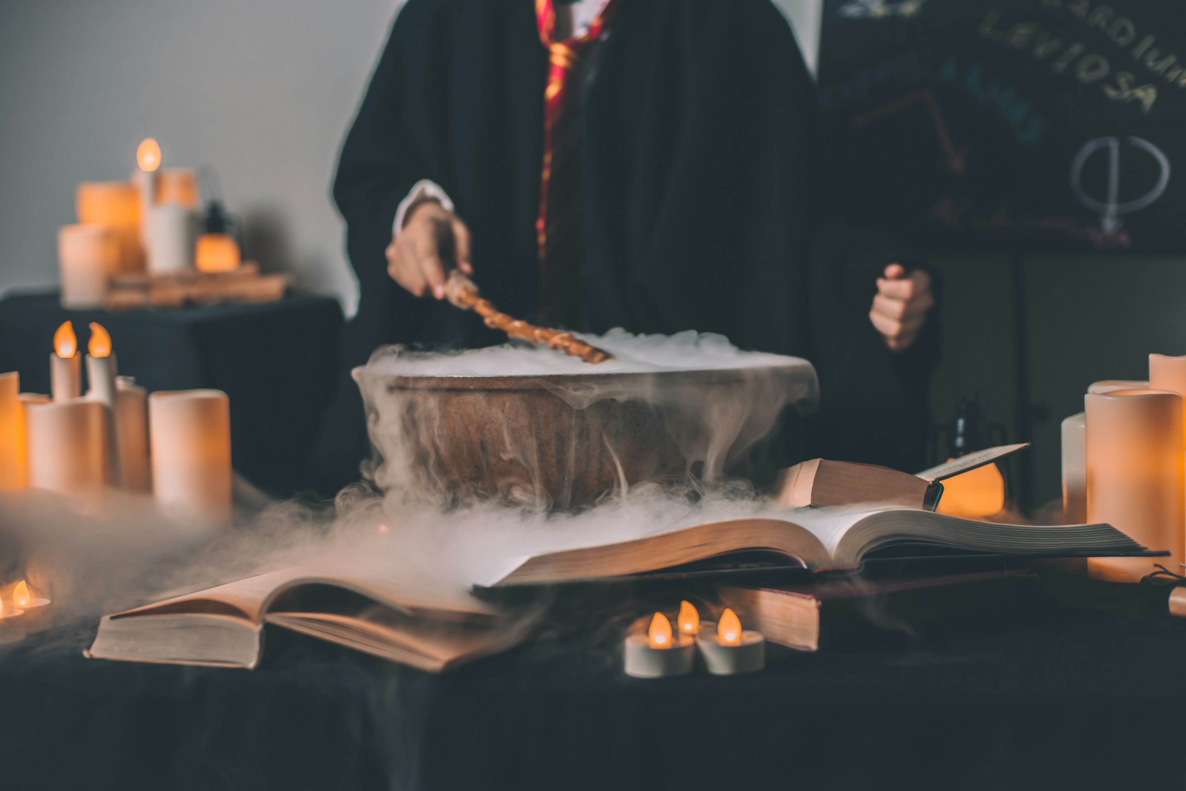 person in robes stirring a smoking cauldron