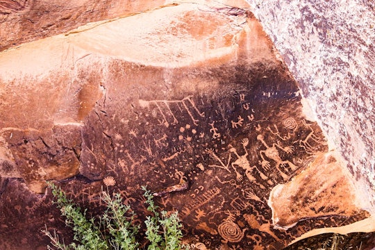 dark varnish on a red rock surface with little drawings carved into it