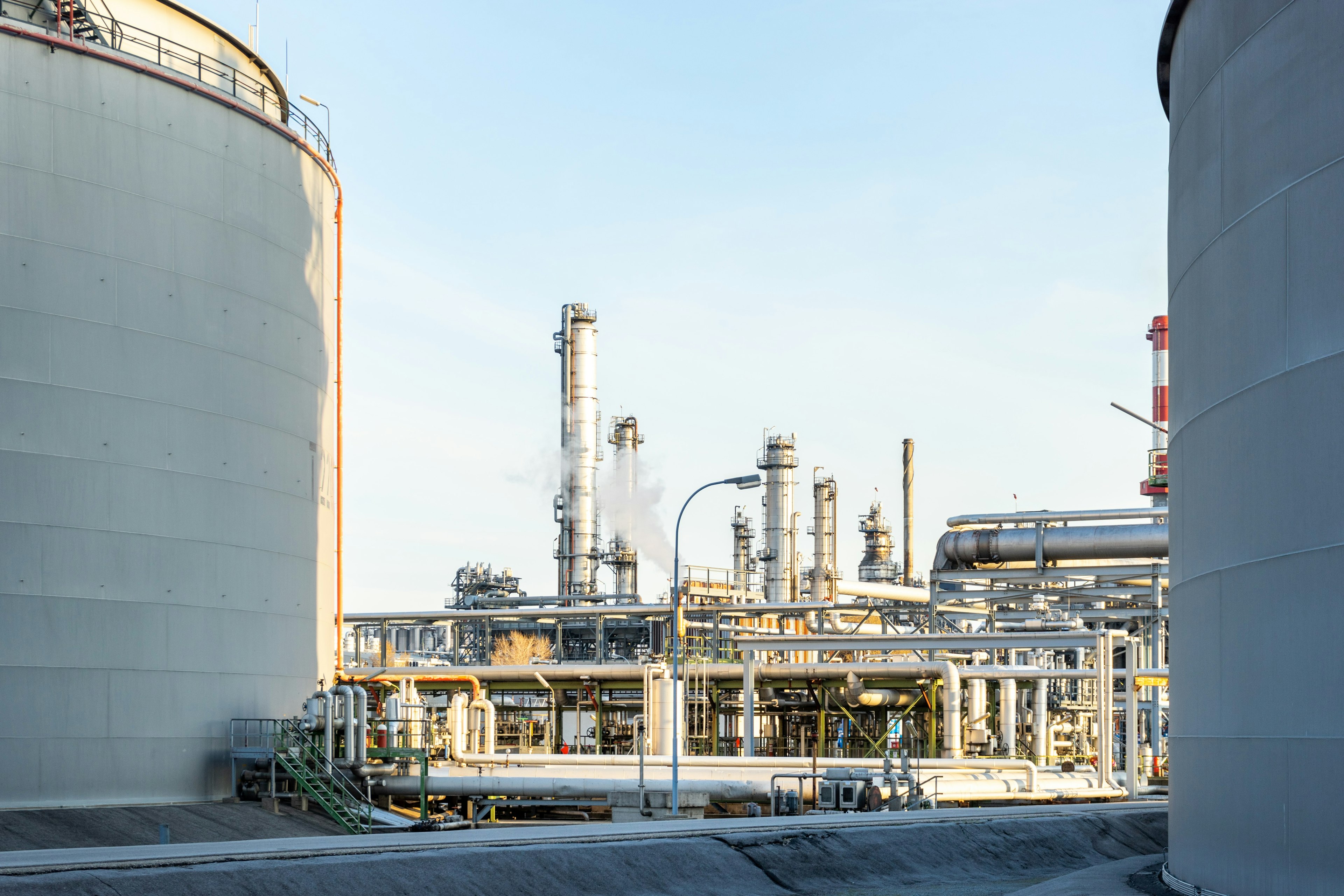 a shot of buildings and pipes in an oil refinery