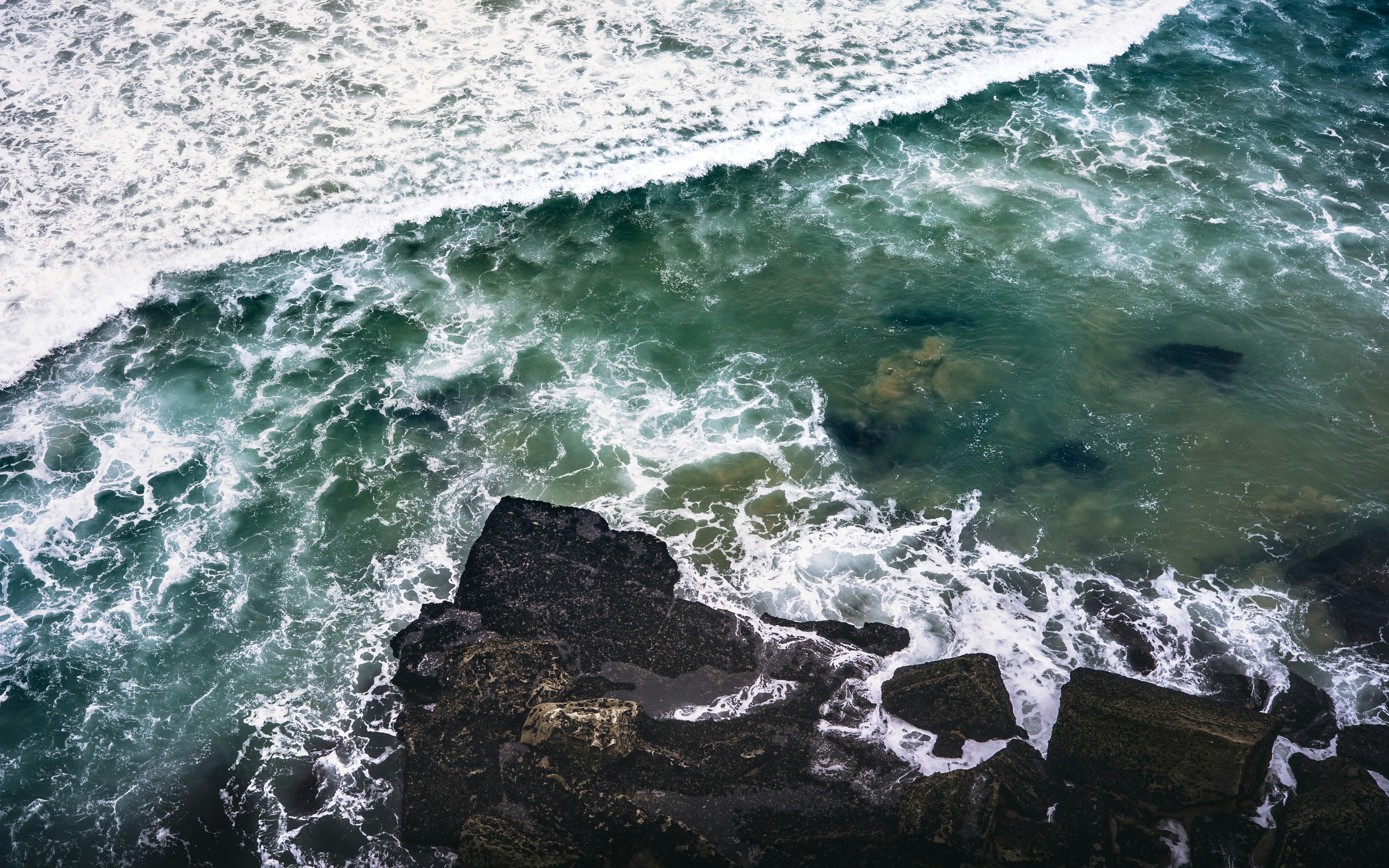 wave crashing on a rocky coast, picture taken from above