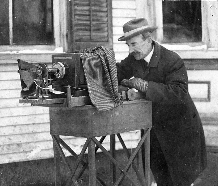 black and white photo of a man tinkering with photographic equipment
