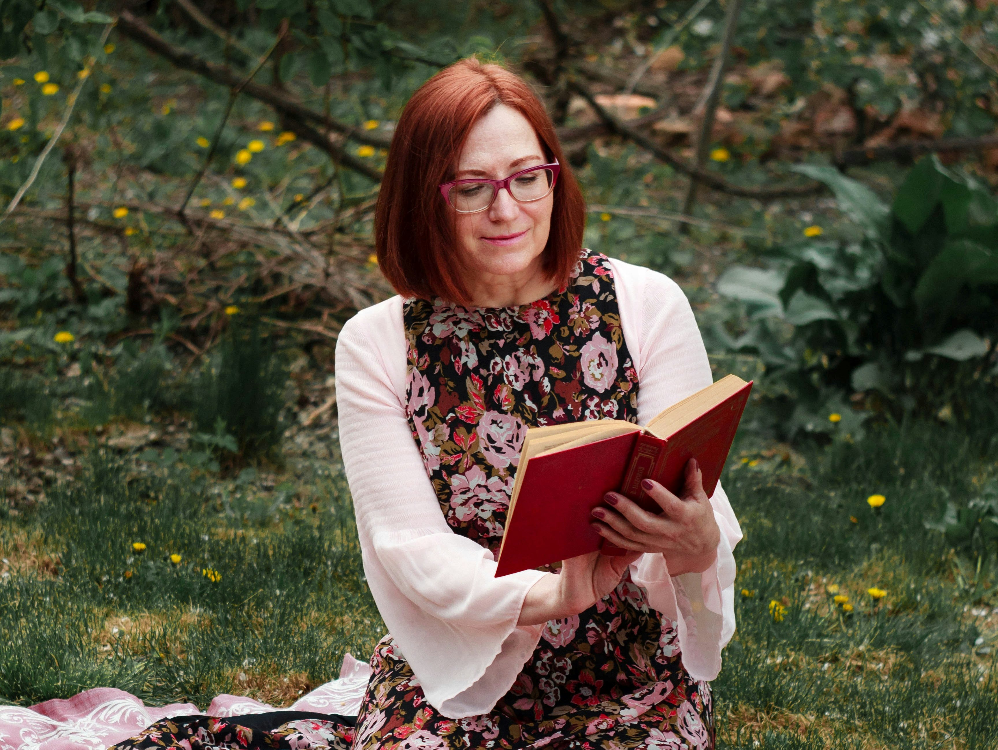 a woman reading from a book outside