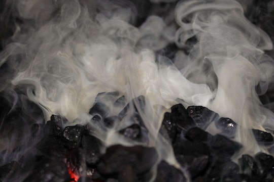 Hot coals giving off clouds of smoke.