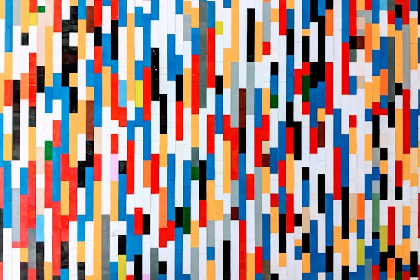 a wall of differently colored legos making a pattern of lines
