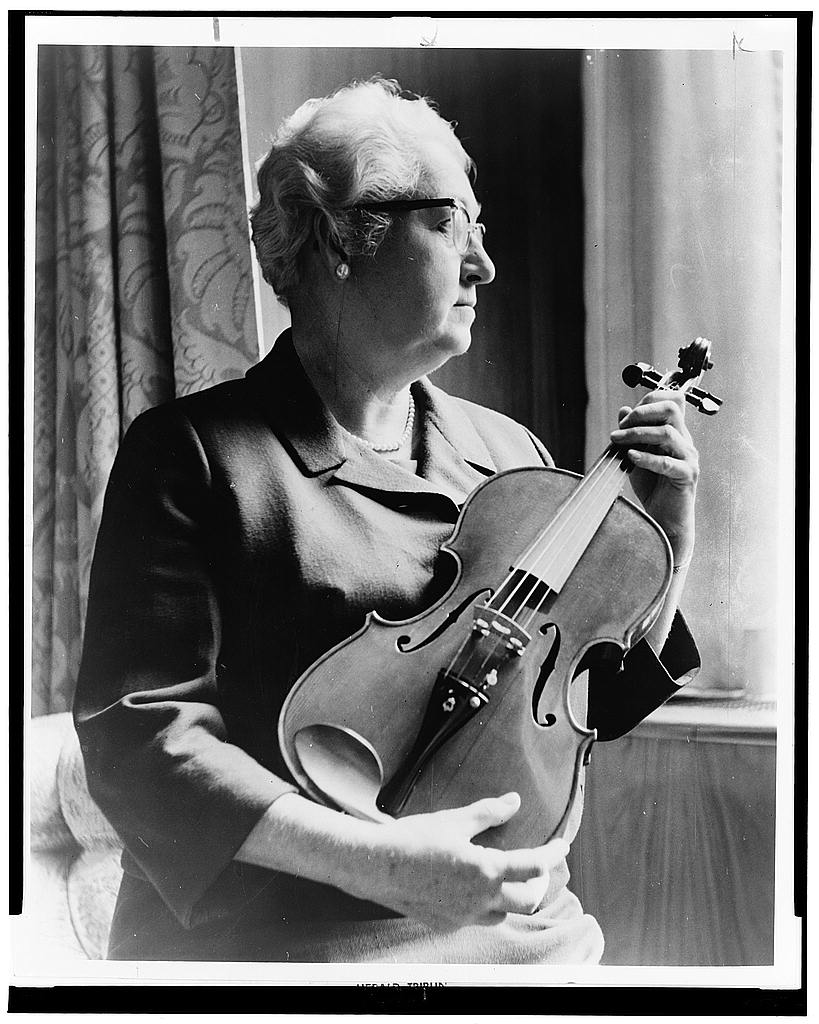 Apgar, a musician as well, examining a violin "fashioned from an old telephone shelf"