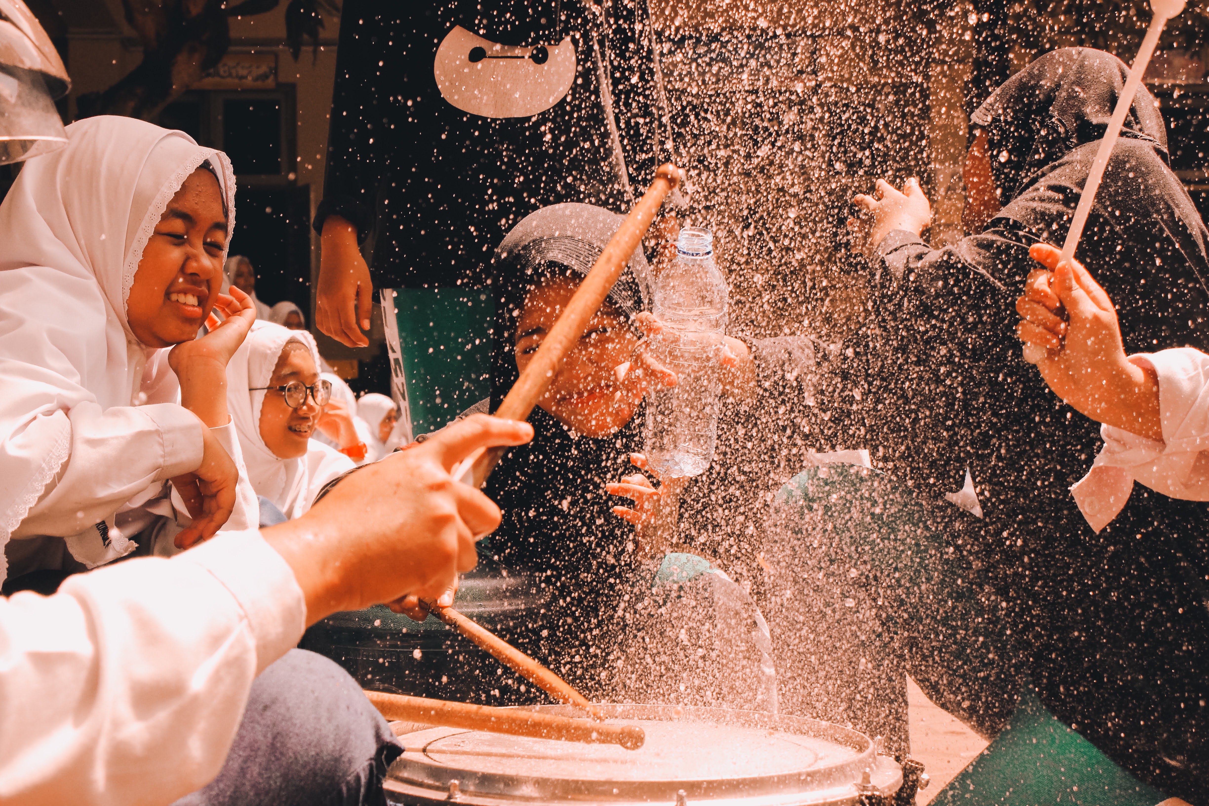 girls in Indonesia playing drums and smiling