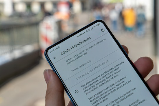 A cell phone with COVID-19 information displayed