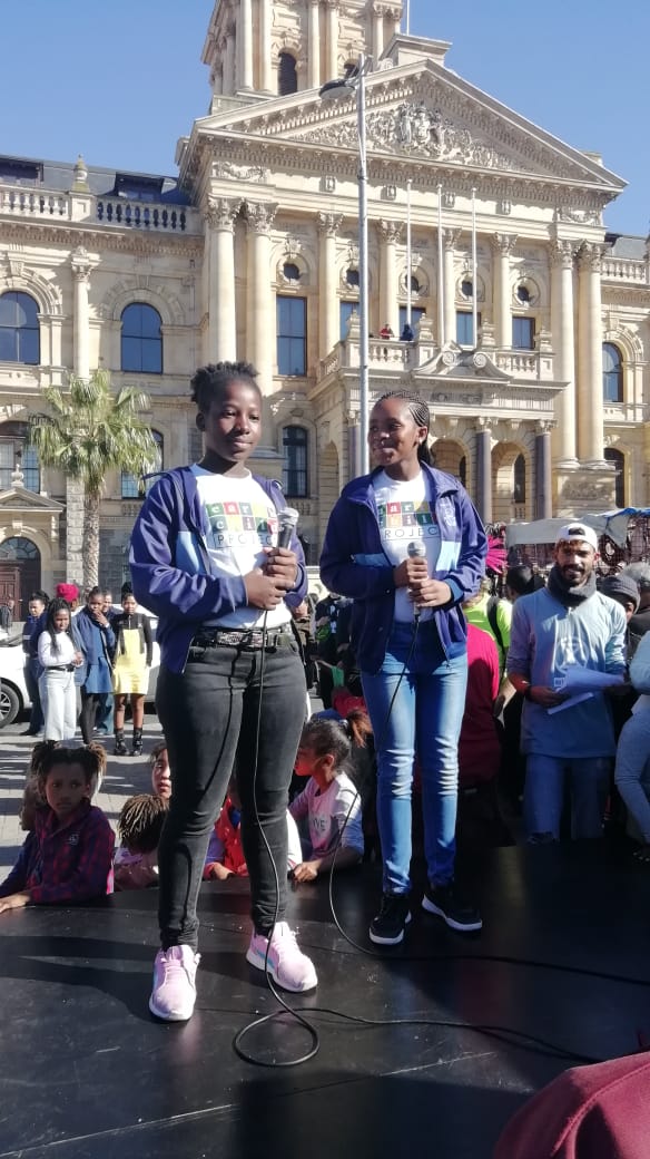 Two climate strikers stand on a stage about to give a speech in Cape Town, South Africa.