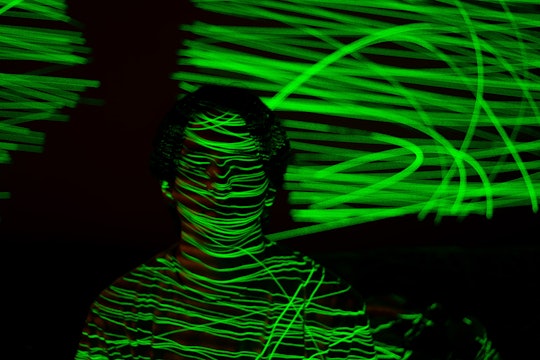 a person covered with green laser-like lights