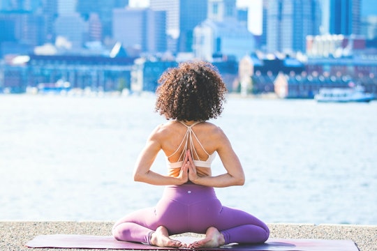 a woman doing yoga on a waterfront