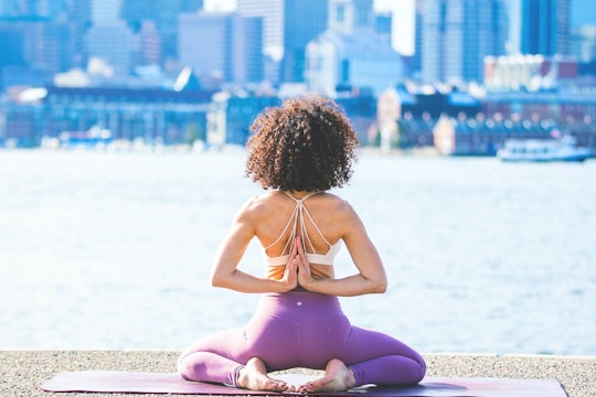women's health yoga a woman doing yoga on a waterfront