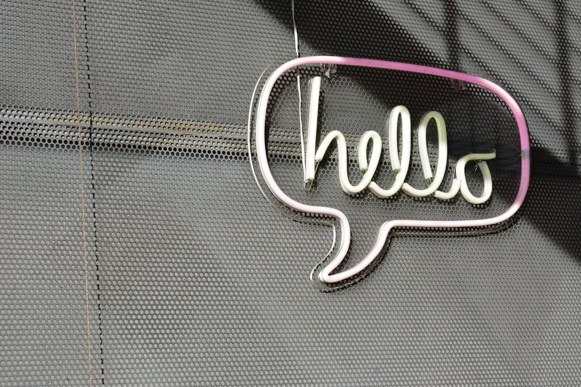 A neon sign in the shape of a speech bubble that says "hello"