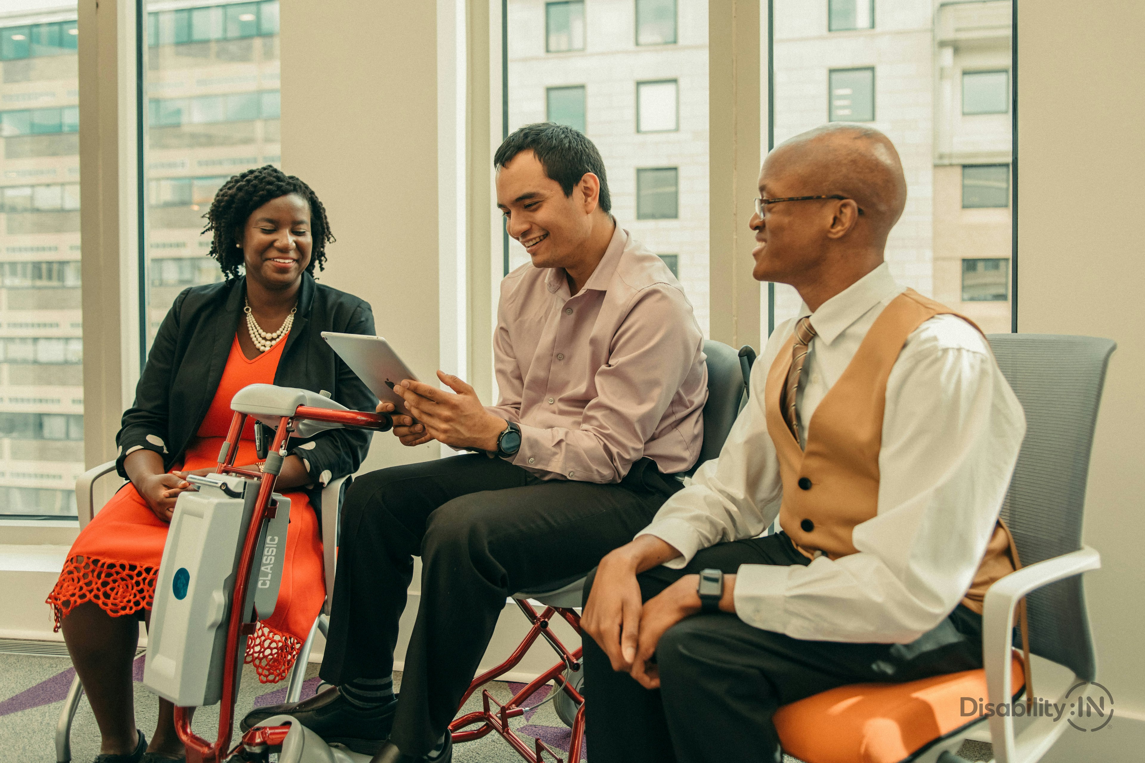 three disabled people with various accommodations working together