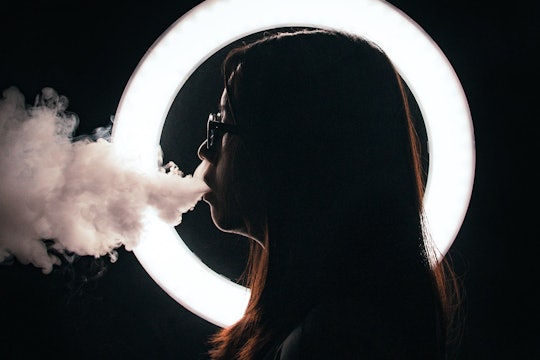 smoking person in profile exhaling smoke